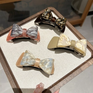 Detail view of acetate bow hair clips in various marble and tortoiseshell patterns