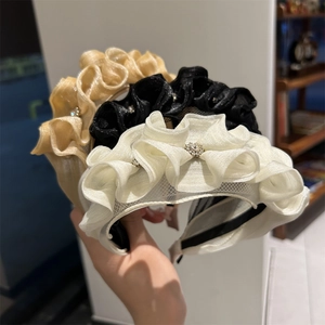 Detailed view of layered organza headbands with pleated mesh and small rhinestone accents