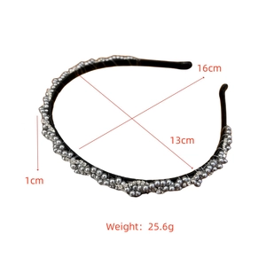 Détail du serre-tête tressé orné de perles argentées et de strass sur monture noire