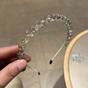 Détail du serre-tête élégant orné de perles de cristal transparentes et couleur champagne