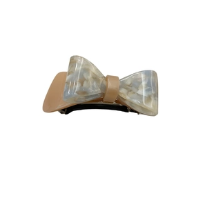Elegant bow-shaped hair clip in milky tea color with marble textured acetate finish