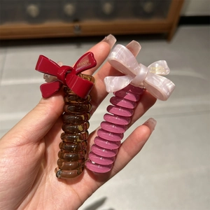 Close-up of spiral hair ties with bows featuring gold France Handmade lettering