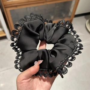 Elegant black satin scrunchie with lace trim and sparkling beads for sophisticated hair styling