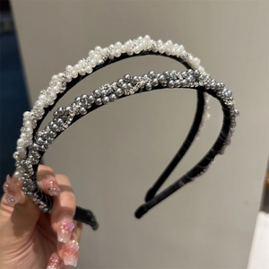 Détail de serre-têtes tressés avec perles élégantes et strass brillants tenus à la main