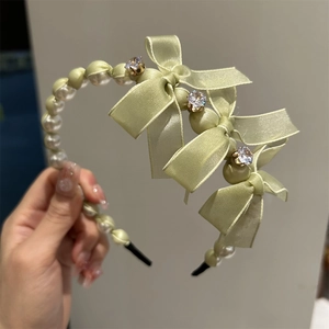 Elegant light green satin bow headband with white pearls and sparkling rhinestone accents