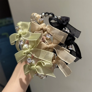Detail showing elegant side-knotted bow headbands with faux pearls and rhinestones