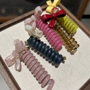 Macro shot of colorful spiral telephone wire hair ties with handmade resin bow details
