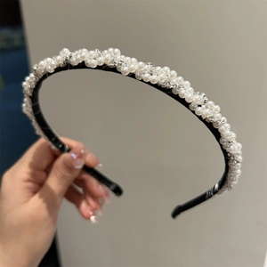 Détail du serre-tête tressé élégant orné de perles blanches et de strass scintillants