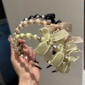 Detailed view of pearl headbands featuring silk bows and sparkling rhinestone accents