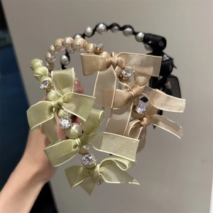 Detailed close-up of pearl headbands with satin bows and rhinestones in three colors