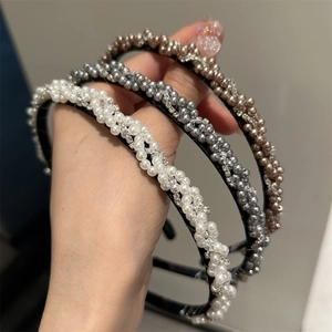 Détail de serre-tête tressé élégant avec strass brillants et perles blanches lisses