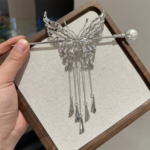 Dettaglio del fermaglio per capelli a farfalla con nappe in zircone e perla decorativa