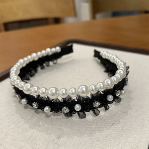 Vue détaillée de la dentelle noire délicate, perles blanches et strass sur le serre-tête