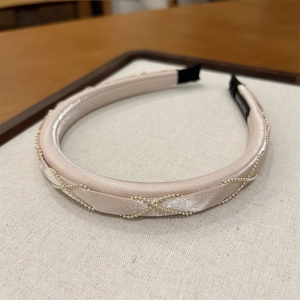 Detailed view of handmade champagne satin headband with elegant golden bead chains