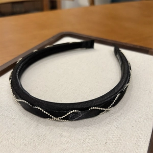 Close-up of elegant black fabric headband featuring a silver metal bead chain design