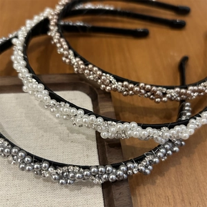 Détail de serre-têtes tressés en perles et cristaux blancs, champagne et gris métal