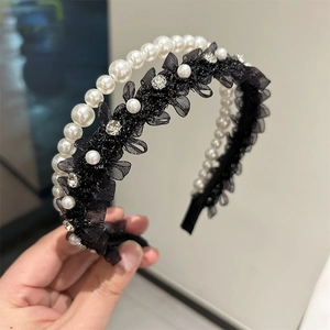 Gros plan d'un serre-tête double couche avec perles blanches et dentelle noire raffinée