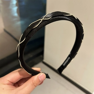 Detail of handmade black silk headband with elegant golden chain lattice pattern