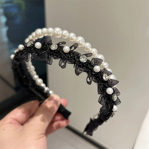 Détail d'un serre-tête double couche avec perles blanches, dentelle noire et strass brillants