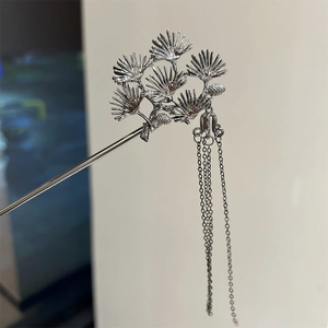 Macro detail of silver pine leaf hair fork with delicate hanging tassel ornaments