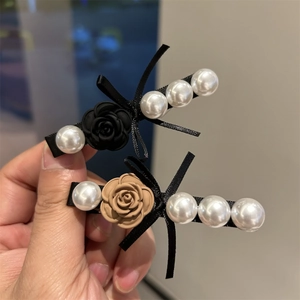 Detail of camellia pearl hair clips set with silk ribbons and resin flower accents