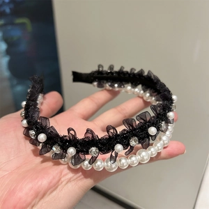 Gros plan du serre-tête en dentelle noire orné de perles et de strass scintillants