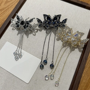 Détail de trois élégantes pinces à cheveux papillon avec des pompons en strass