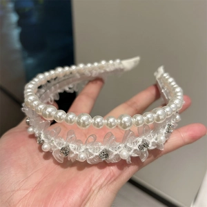 Détail d'un serre-tête double couche avec dentelle blanche, perles et strass brillants