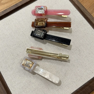 Detailed close-up showing five acetate hair clips with embedded rectangular rhinestones