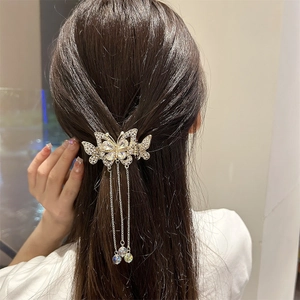 Pince à cheveux papillon dorée élégante avec pompons en cristal sur cheveux longs