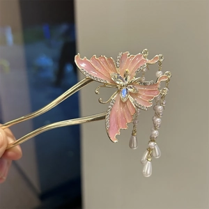 Detail of golden butterfly hair pin with pink wings, rhinestones and pearl tassels