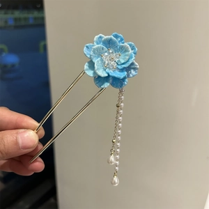Détail de l'épingle à cheveux fleur bleue avec glands en perles blanches et double broche