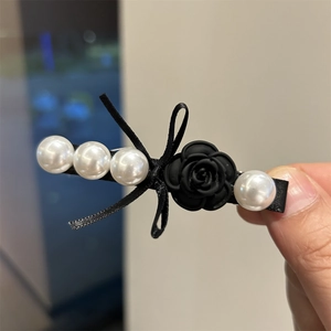 Elegant black camellia hair clip with white pearls and satin ribbon in Chanel style