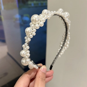 Close-up detail of a handmade pearl beaded headband with intricate woven wire design