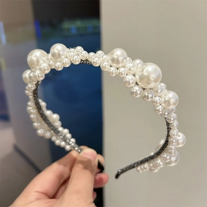 Elegant floral headband featuring white pearls and beads on a sleek black band for women