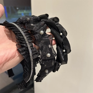 Dettaglio di tre cerchietti in rete nera con perle finte e strass luccicanti eleganti