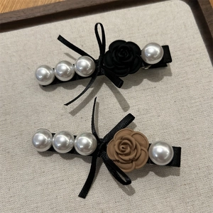 Detailed view of the resin rose and white pearls on the vintage Korean hair clip