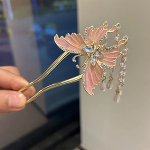 Detailed macro view of pink butterfly hair pin with pearls and U-shaped metal fork