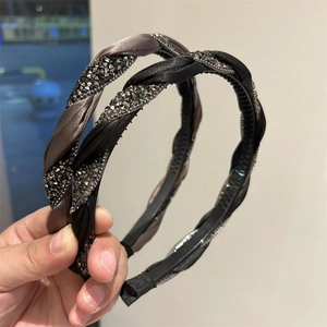 Detail view of two braided headbands with sparkling rhinestones in black and dark brown