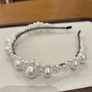 Elegant pearl headband featuring intricate beaded flower patterns on a dark woven base
