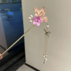 Detailed macro view of golden hair pin with butterfly tassel and purple flower detail