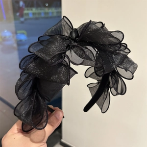 Dettaglio del cerchietto in rete nera con glitter argento scintillanti e pieghe