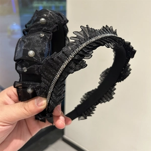 Dettaglio di cerchietti in rete nera con perle, strass e trama a pieghe elegante