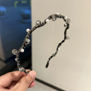 Detail of woven crystal headband featuring grey beads and pearls on thin metal wire