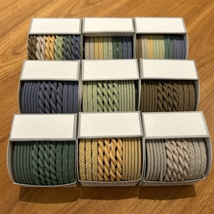 Detail view of woven high elasticity hair bands in various colors on wooden surface