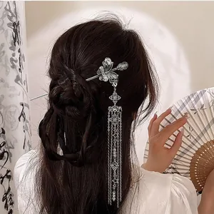 Detail of silver butterfly hair stick with long tassels on a traditional hairstyle