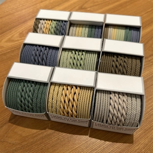 Detailed view of woven elastic hair bands in nine colorful sets on a wooden desk