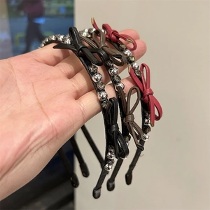 Detailed view of rhinestone bow headbands in black, dark brown, and wine red colors