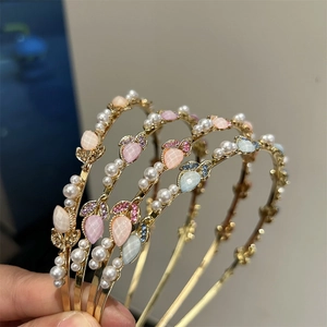 Dettaglio di un elegante cerchietto dorato con pietre di ibisco perle e accenti di tulipani
