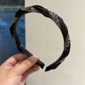 Macro shot of black braided headband with crystals and anti-slip inner comb teeth